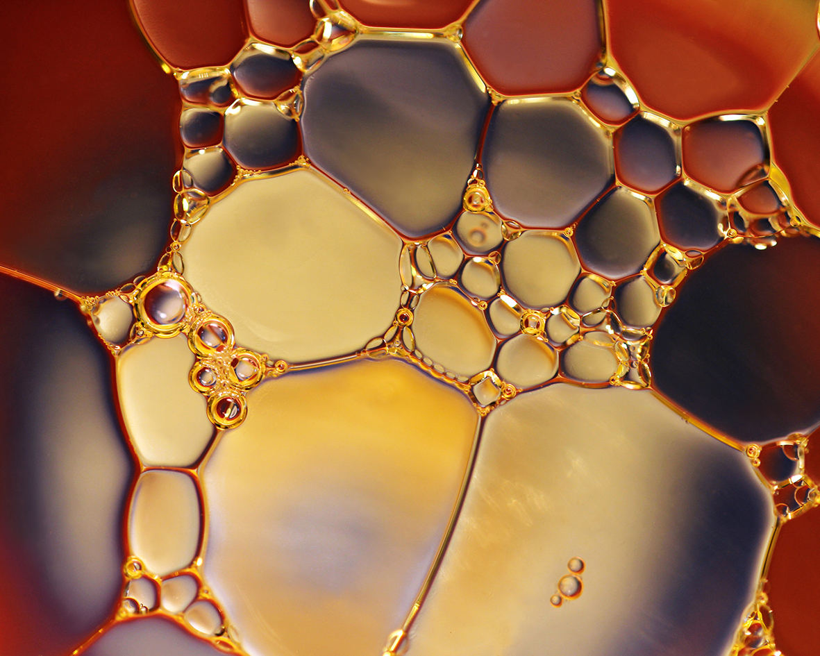Melted palm oil with oil eyes and a golden-yellow colour.